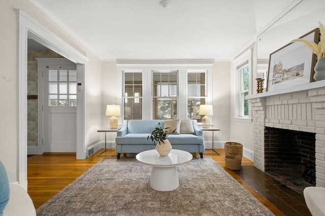living area featuring plenty of natural light, baseboards, and crown molding