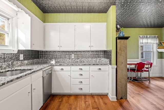 kitchen with white cabinets, stainless steel dishwasher, and sink