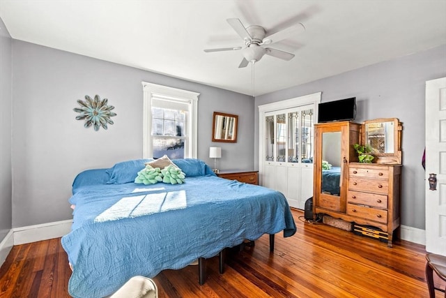 bedroom featuring ceiling fan, dark wood-type flooring, and multiple windows