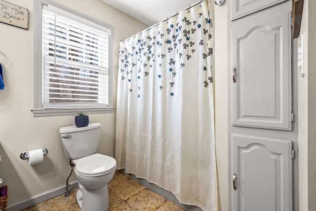 bathroom featuring tile patterned floors, toilet, and plenty of natural light