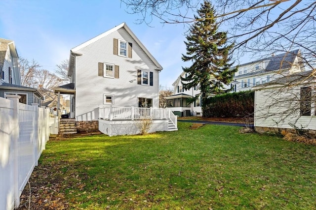 rear view of property featuring a yard and a deck