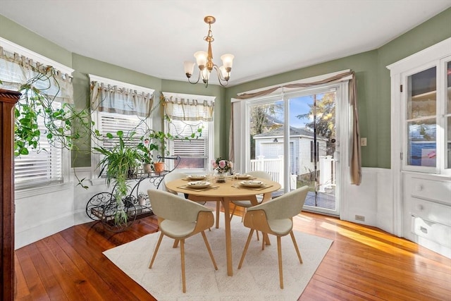 dining space featuring hardwood / wood-style flooring and a notable chandelier