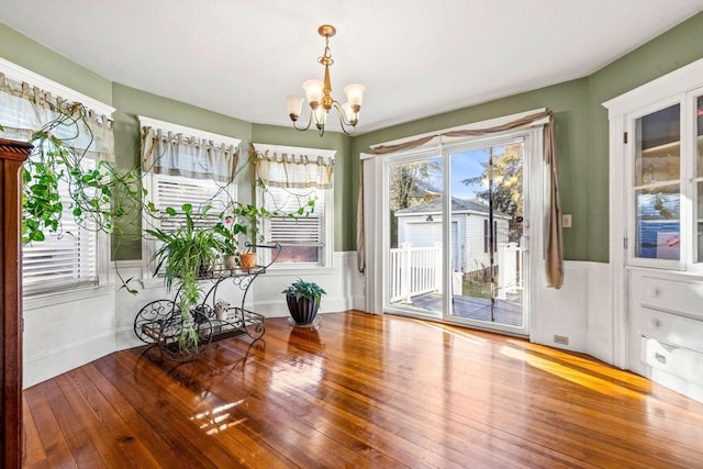 entryway with hardwood / wood-style floors and a notable chandelier