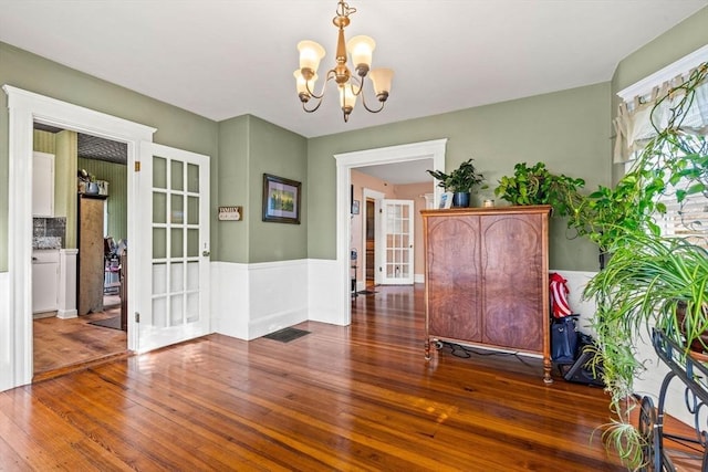 unfurnished dining area featuring a notable chandelier and dark wood-type flooring