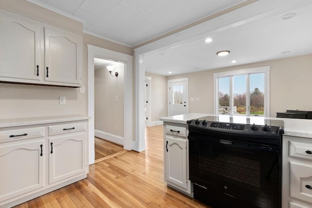 kitchen featuring white cabinets, light countertops, light wood-style floors, crown molding, and electric range