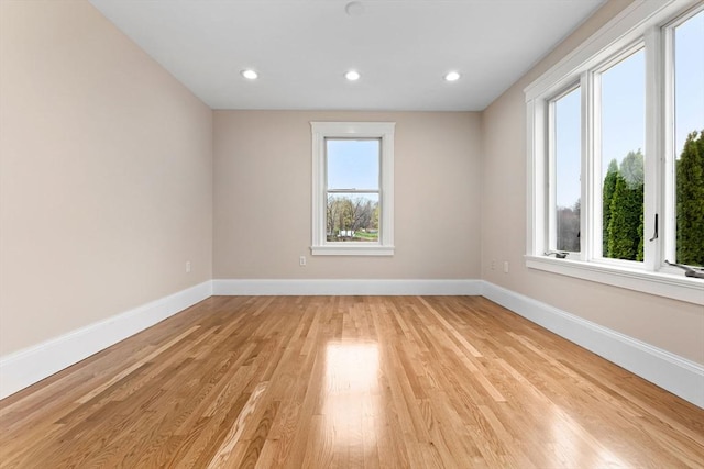 empty room featuring recessed lighting, baseboards, and light wood-style flooring