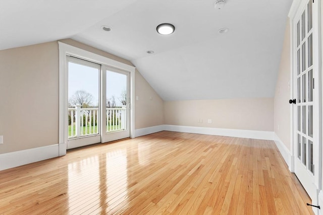 bonus room featuring baseboards, lofted ceiling, and light wood-style flooring