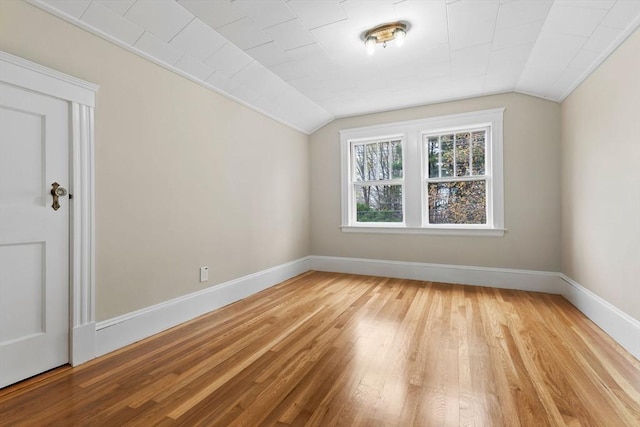 bonus room featuring baseboards, lofted ceiling, and light wood-style flooring