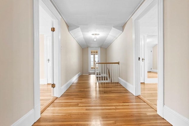 hallway featuring light wood-type flooring and baseboards