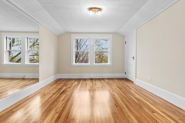 bonus room with lofted ceiling, light wood finished floors, and baseboards