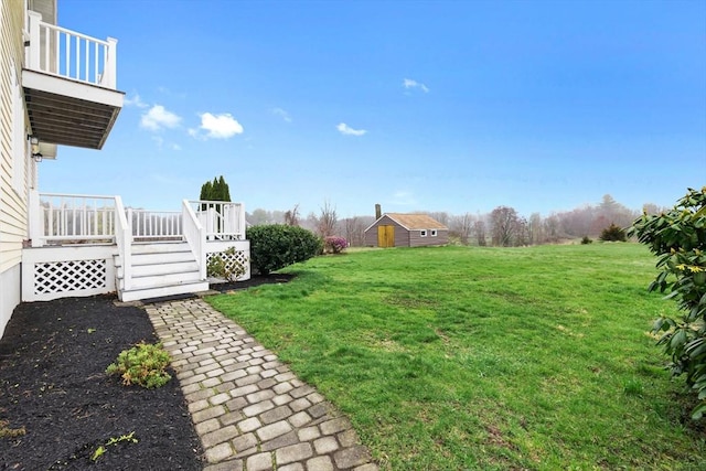 view of yard featuring an outbuilding, a deck, and a balcony