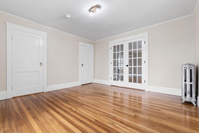 empty room with radiator, baseboards, french doors, and wood finished floors