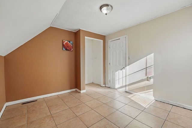 interior space with lofted ceiling and light tile patterned flooring