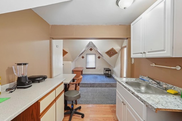 home office featuring light hardwood / wood-style floors, lofted ceiling, and sink