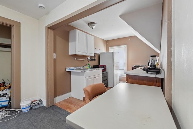 kitchen featuring white cabinets and white refrigerator