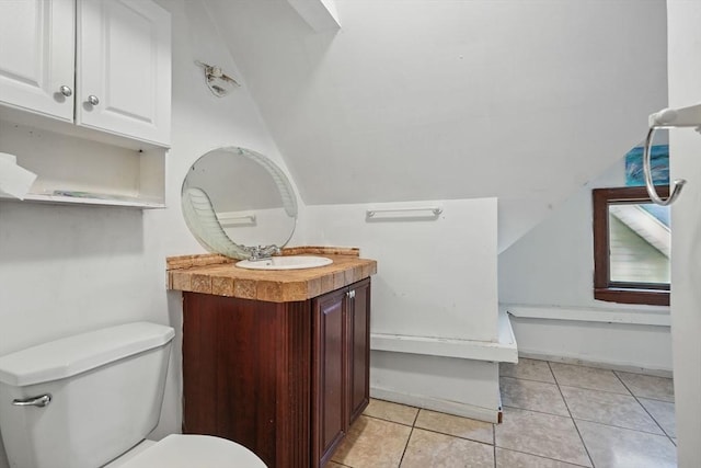 bathroom featuring tile patterned floors, vanity, vaulted ceiling, and toilet