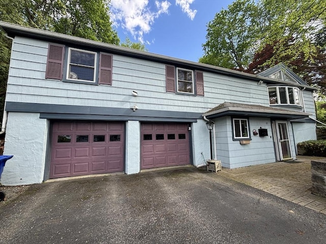 12 Inis Cir, Newton, MA 02465 - view of front of property with asphalt driveway, a garage, and stucco siding