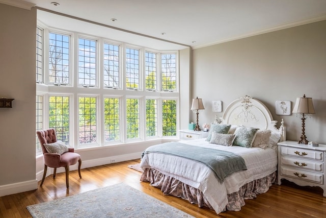 bedroom with hardwood / wood-style floors and ornamental molding