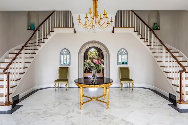 entrance foyer with a high ceiling, an inviting chandelier, and tile flooring