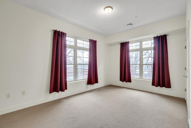 carpeted empty room featuring a wealth of natural light