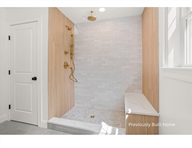 bathroom with tile patterned flooring and a tile shower