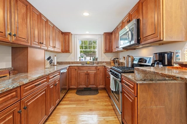 9 Emerson Ct, Winchester, MA 01890 - kitchen featuring stainless steel appliances, brown cabinetry, light wood finished floors, recessed lighting, and light stone counters