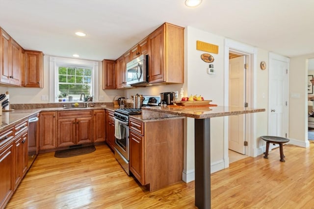9 Emerson Ct, Winchester, MA 01890 - kitchen with stainless steel appliances, light wood-style floors, brown cabinets, and recessed lighting
