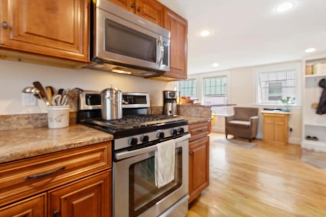 9 Emerson Ct, Winchester, MA 01890 - kitchen featuring stainless steel appliances, brown cabinetry, recessed lighting, light wood finished floors, and light stone counters