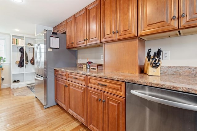 9 Emerson Ct, Winchester, MA 01890 - kitchen featuring appliances with stainless steel finishes, brown cabinetry, light wood-style flooring, light stone countertops, and recessed lighting