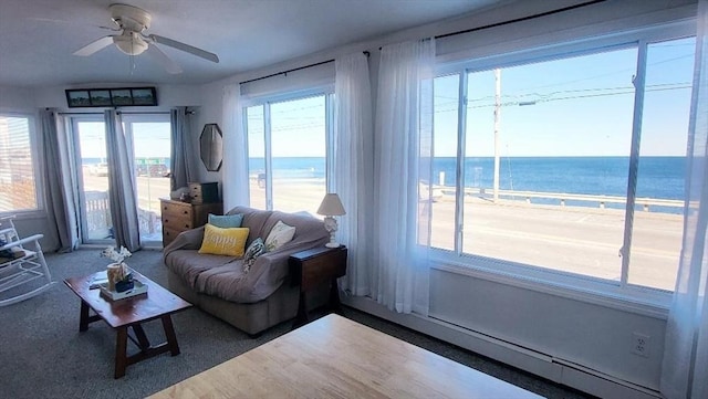 living room with ceiling fan and a water view