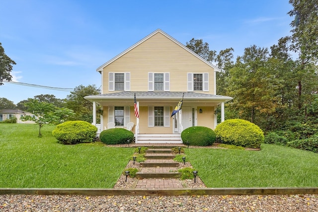 farmhouse-style home featuring covered porch and a front yard