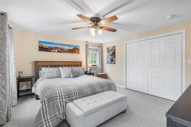 carpeted bedroom with ceiling fan and a closet