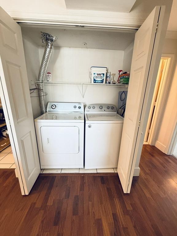 washroom with laundry area, dark wood finished floors, and washing machine and dryer