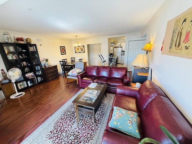 living area with crown molding, wood finished floors, and a chandelier
