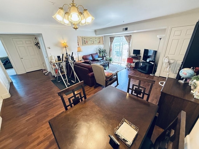 dining room featuring visible vents, ornamental molding, wood finished floors, and a chandelier