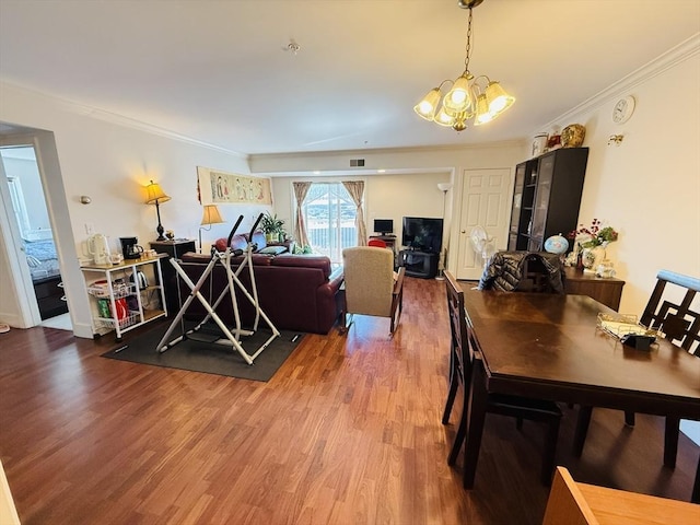 living room featuring crown molding, visible vents, wood finished floors, and a notable chandelier