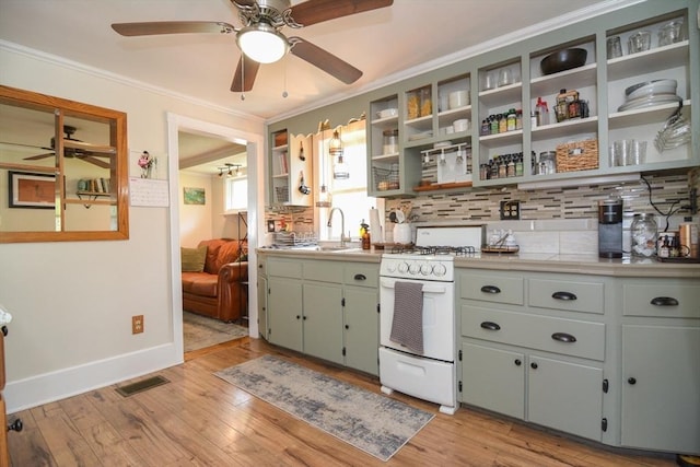 82 Circuit Ave, Weymouth, MA 02188 - kitchen with white gas range oven, ceiling fan, backsplash, crown molding, and open shelves