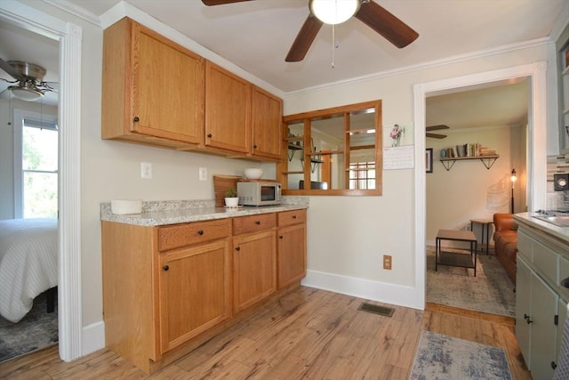 82 Circuit Ave, Weymouth, MA 02188 - kitchen with a ceiling fan, light countertops, light wood finished floors, baseboards, and crown molding