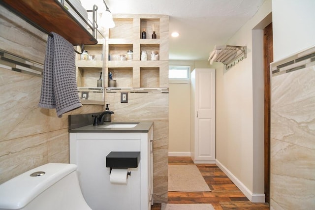 82 Circuit Ave, Weymouth, MA 02188 - bathroom with wood finished floors, tile walls, vanity, toilet, and baseboards