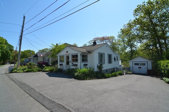 82 Circuit Ave, Weymouth, MA 02188 - view of front of house with a storage shed, asphalt driveway, an outbuilding, and a detached garage