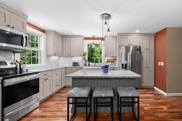 241 W Main St, Westborough, MA 01581 - kitchen with appliances with stainless steel finishes, a breakfast bar area, wood finished floors, backsplash, and recessed lighting
