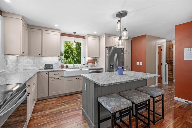 241 W Main St, Westborough, MA 01581 - kitchen featuring stainless steel appliances, a kitchen breakfast bar, decorative backsplash, hardwood / wood-style floors, and a center island