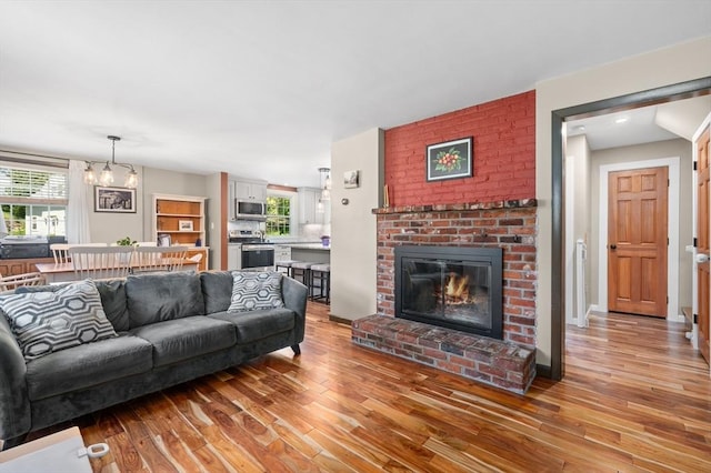 241 W Main St, Westborough, MA 01581 - living area featuring wood finished floors, a fireplace, and a chandelier