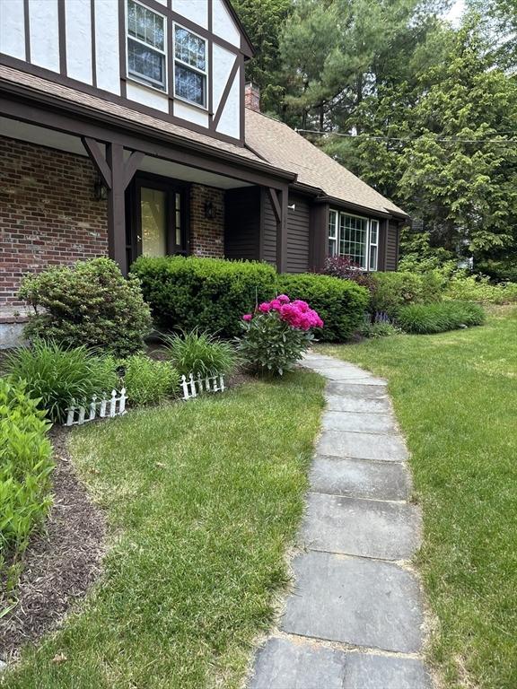 369 Border Rd, Concord, MA 01742 - view of side of home featuring a lawn, brick siding, a porch, and a shingled roof