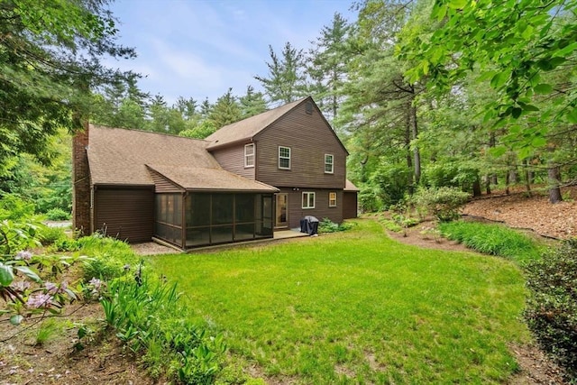 369 Border Rd, Concord, MA 01742 - back of property featuring a sunroom, a chimney, a lawn, and roof with shingles