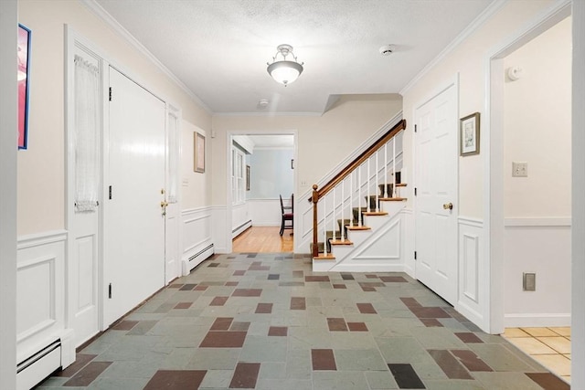 369 Border Rd, Concord, MA 01742 - foyer entrance with baseboard heating, a decorative wall, crown molding, stairway, and a wainscoted wall