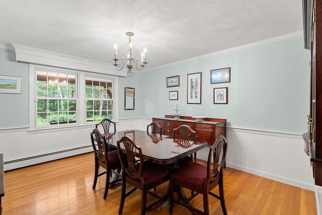 369 Border Rd, Concord, MA 01742 - dining space with a baseboard radiator, a chandelier, light wood-type flooring, crown molding, and a textured ceiling