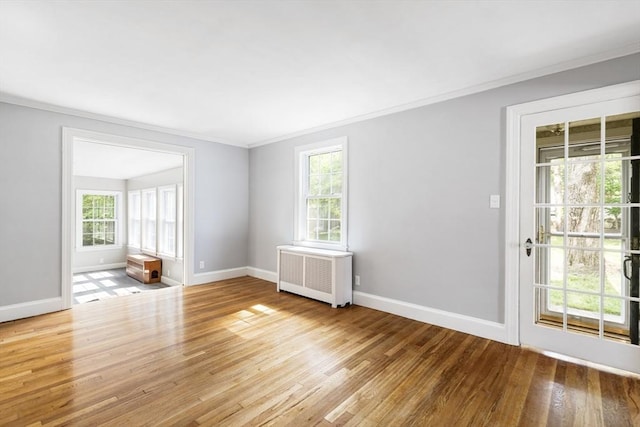 spare room with radiator, ornamental molding, and light hardwood / wood-style flooring