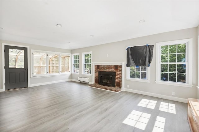 unfurnished living room featuring a fireplace and light hardwood / wood-style flooring