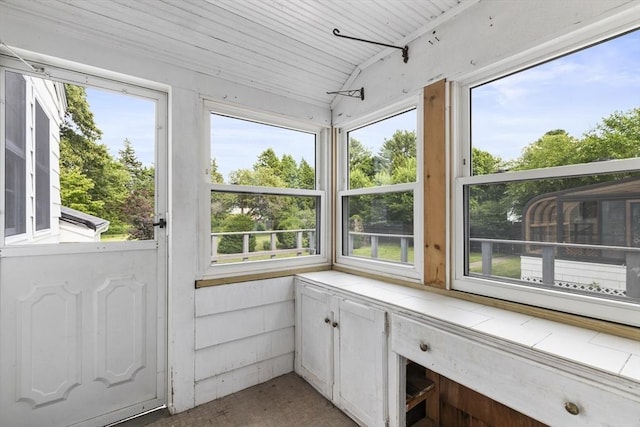 sunroom with plenty of natural light and lofted ceiling